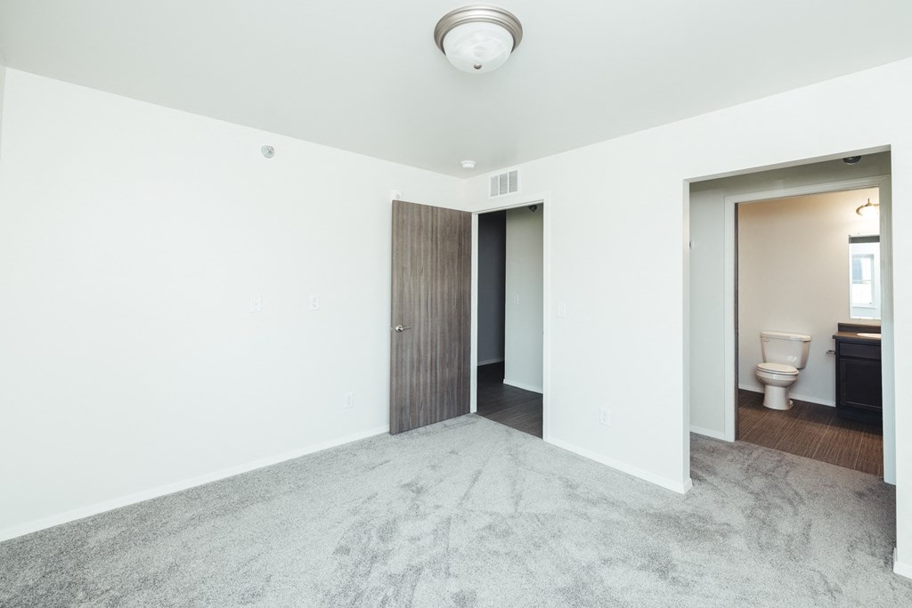 an empty room with a toilet and a door to a bathroom