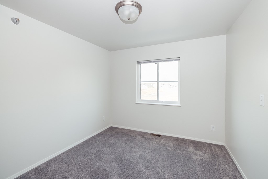 an empty room with carpet and a window
