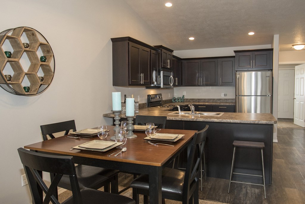 an open kitchen and dining area with a wooden table and chairs