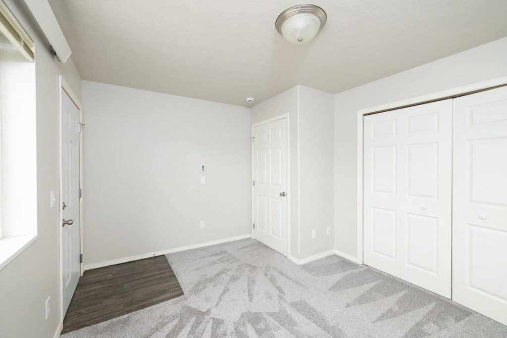 A room with a carpeted floor and white walls.