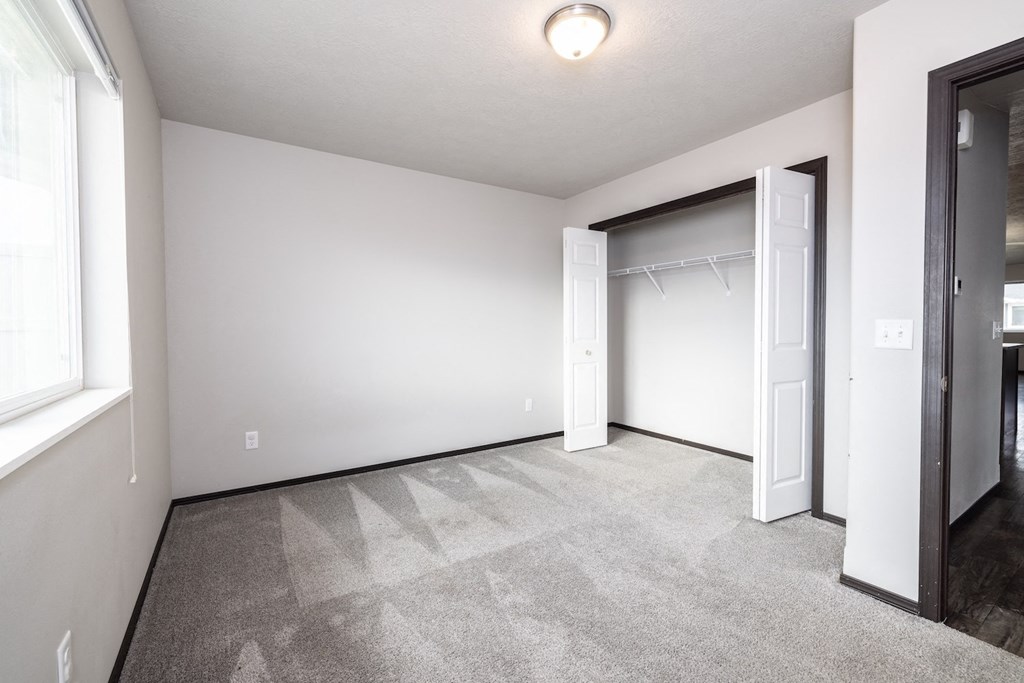 A room with a carpeted floor and a sliding door.