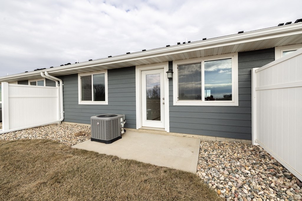 A house with a grey siding and a white garage door.