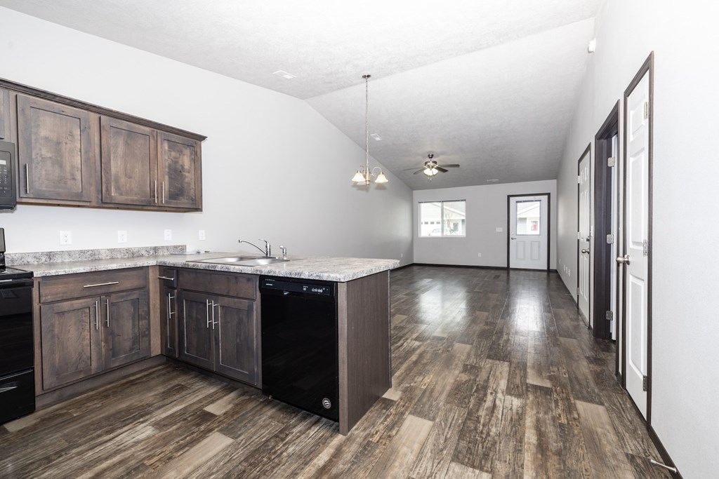 A kitchen with dark wood cabinets and a white counter top.