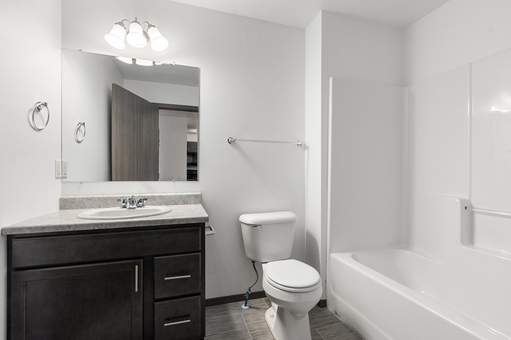 A white bathroom with a toilet, sink, and bathtub.