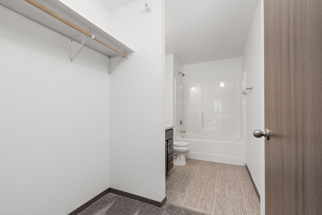 A white bathroom with a toilet, sink, and mirror.