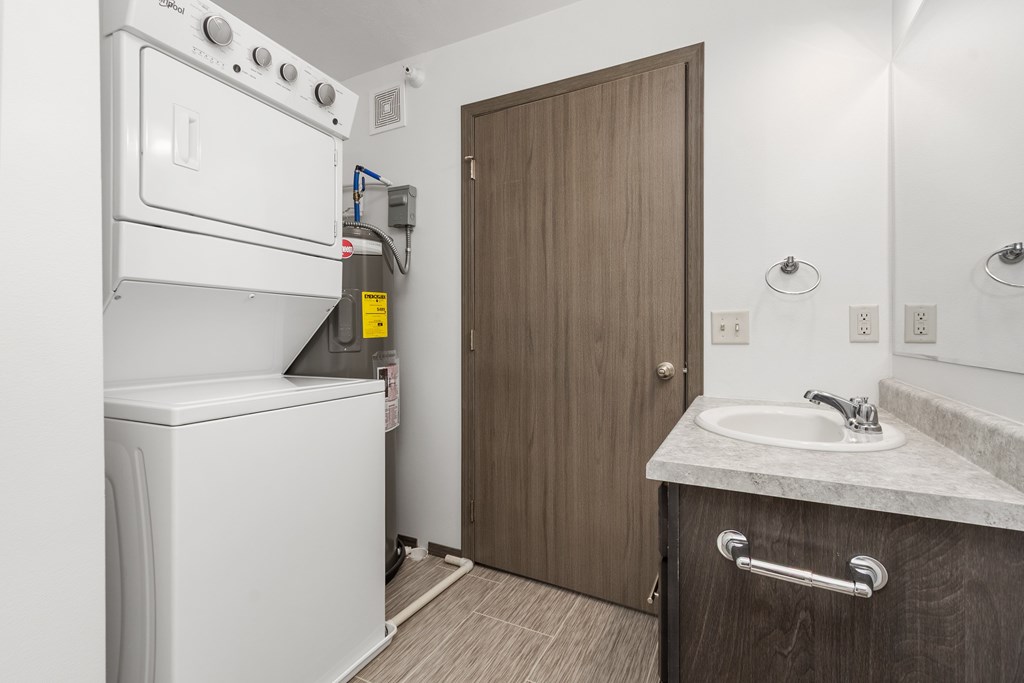 A small bathroom with a washer and dryer built into the cabinetry.