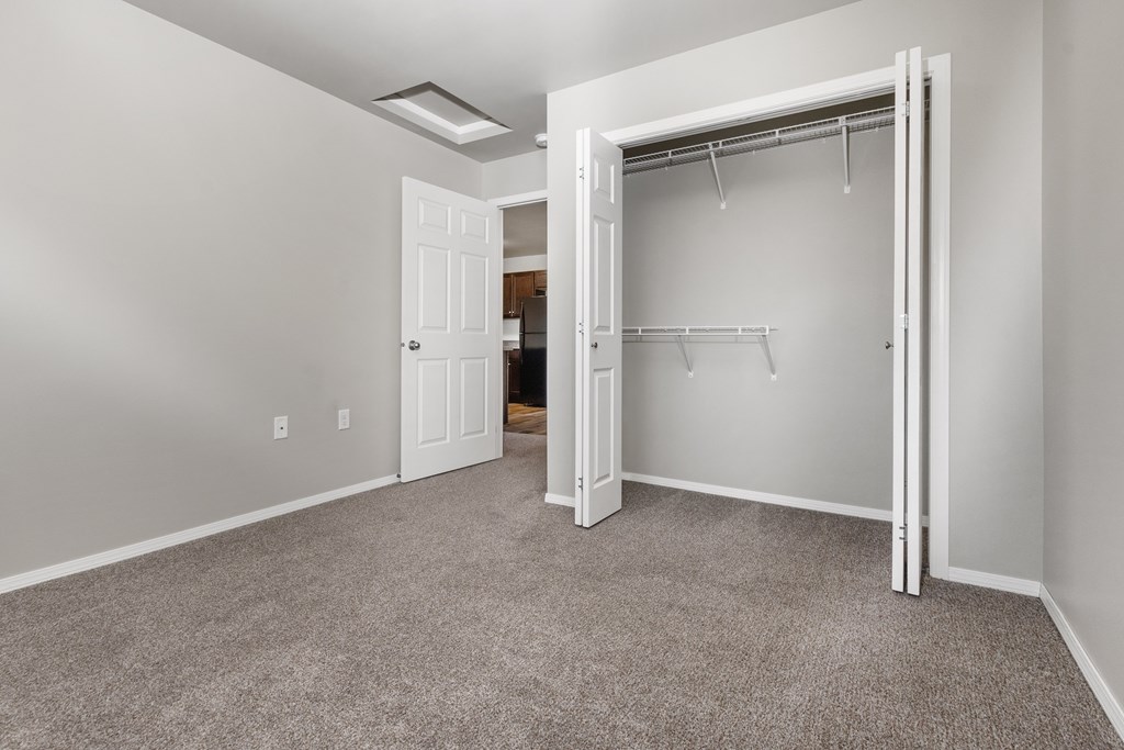 A room with a carpeted floor and a white door.