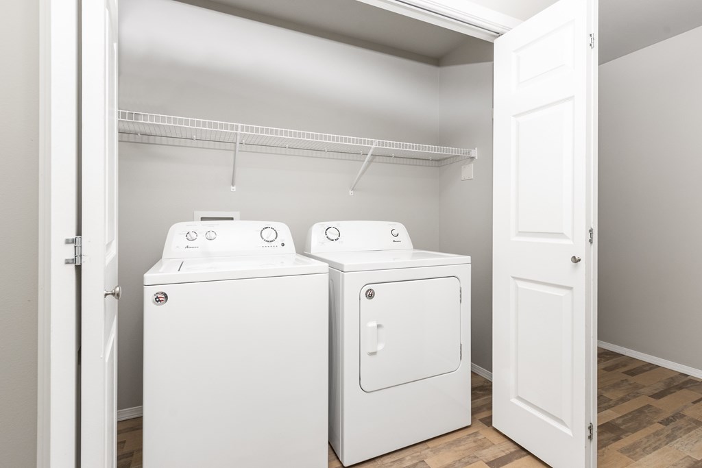 Two white washing machines in a laundry room.