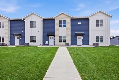 A row of houses with blue doors and windows.