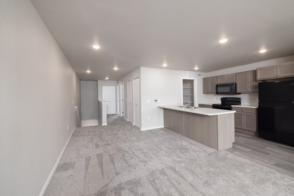 A spacious living room with a television and a kitchen area.