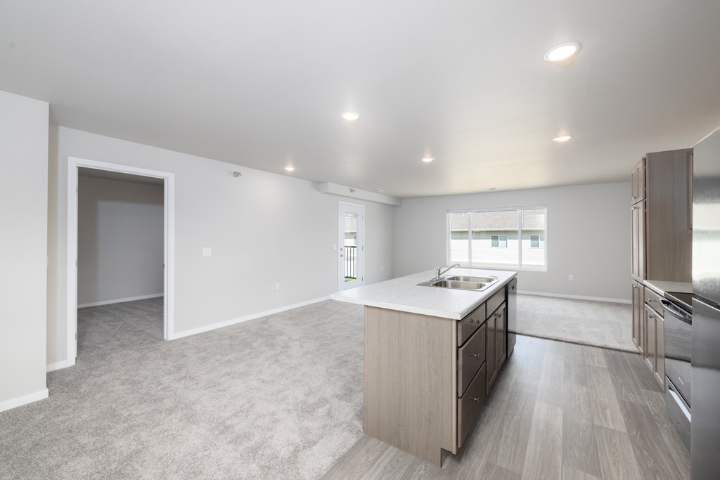A kitchen with a sink, stove, and refrigerator.