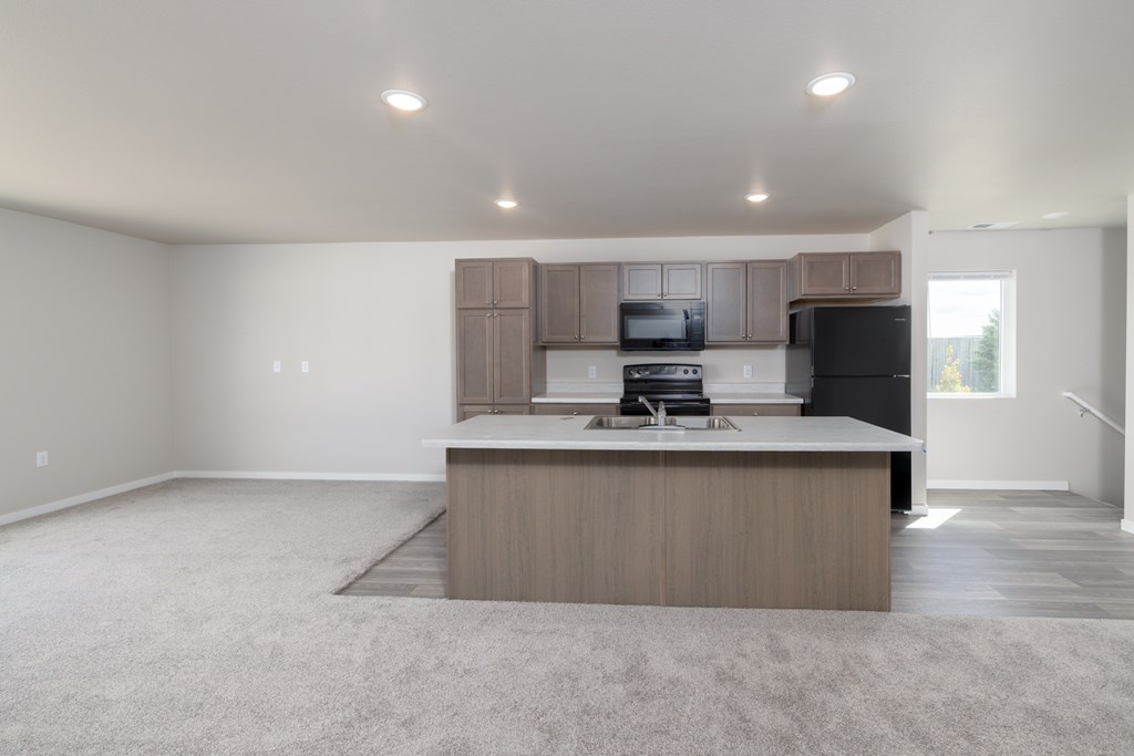 A kitchen with a white countertop and a microwave above it.