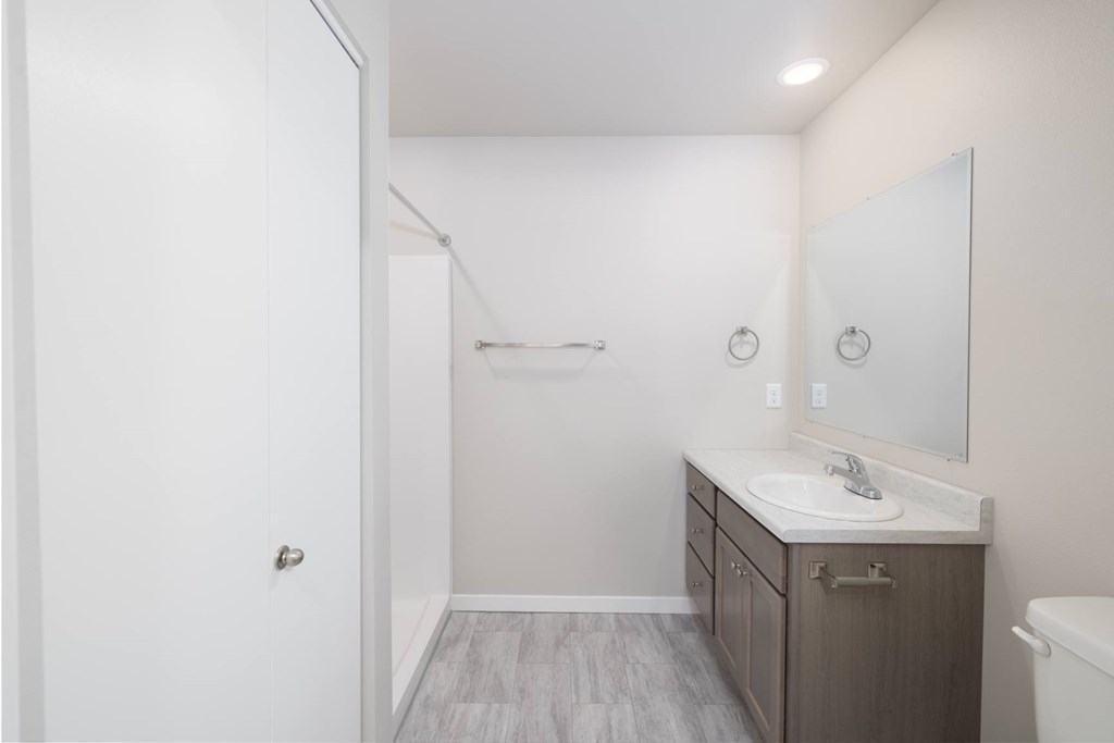 A bathroom with a sink, mirror, and toilet.