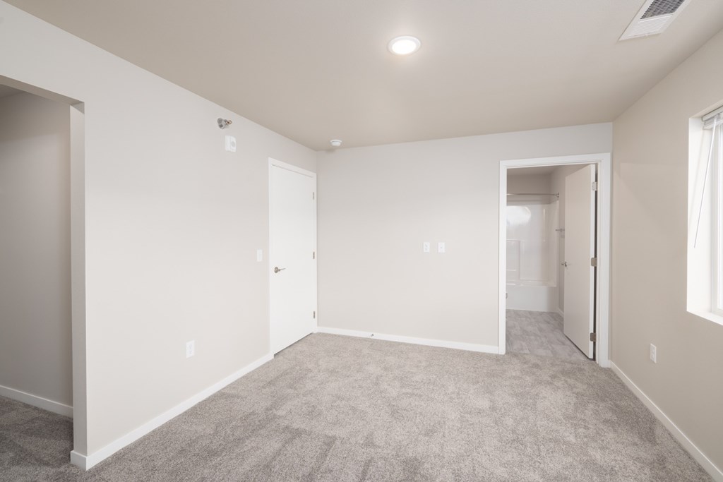 A spacious room with carpeted floor and white walls.