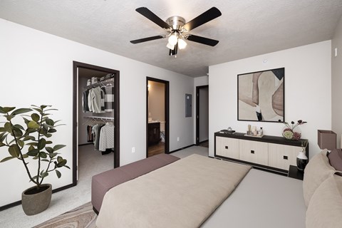 A bedroom with a bed, dresser, and mirror.