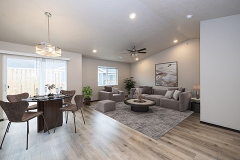 A modern living room with a dining table and chairs.