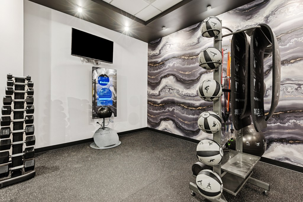 A room with a white wall and a black television on the wall.