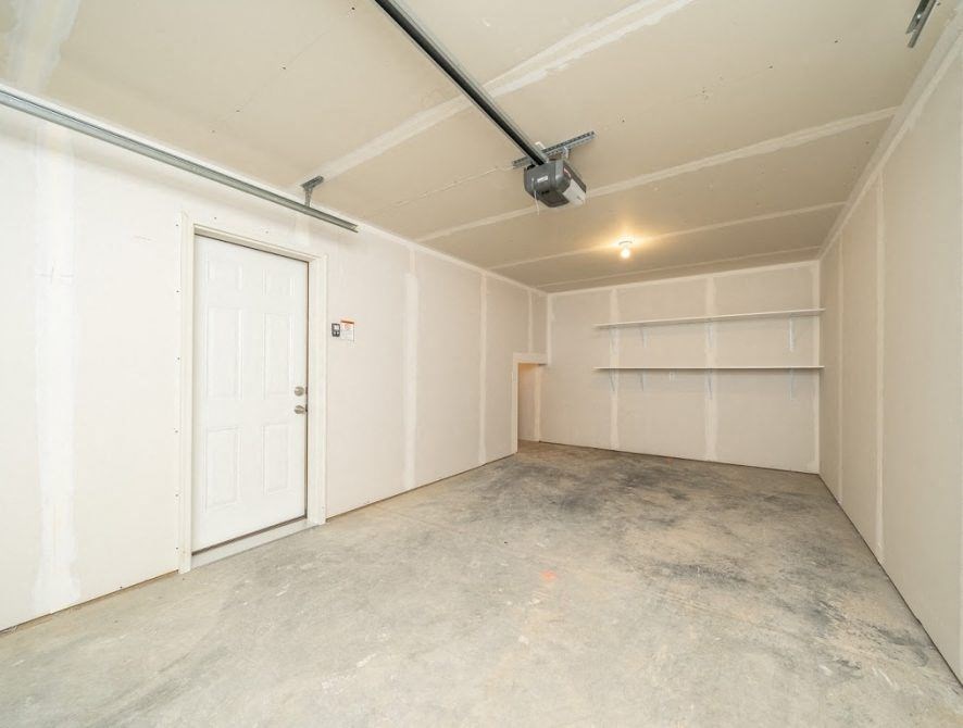 an empty garage with a white door and white walls