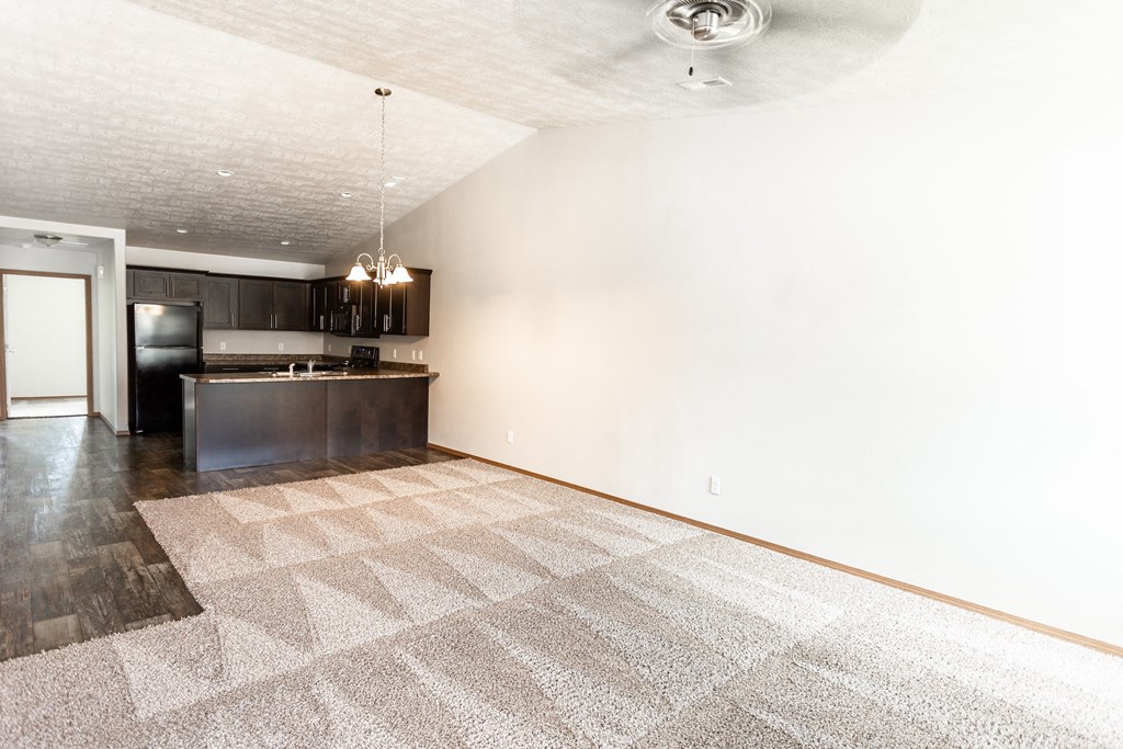 the living room and kitchen of an empty apartment