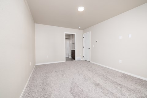 A spacious room with carpeted floor and white walls.