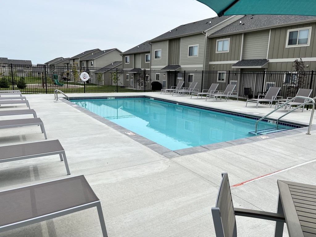 Sparkling blue pool surrounded by lounge chairs.