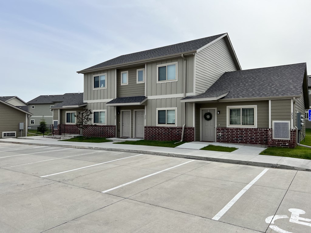 an empty parking lot in front of a house
