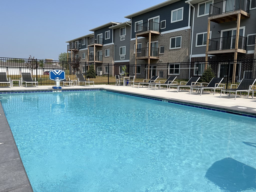 a swimming pool in front of an apartment building