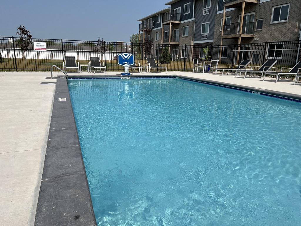 an empty pool with an apartment building in the background
