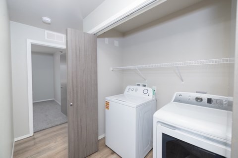 A small kitchen with a white oven and a white cabinet.