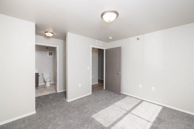 A room with a carpeted floor and a ceiling light.
