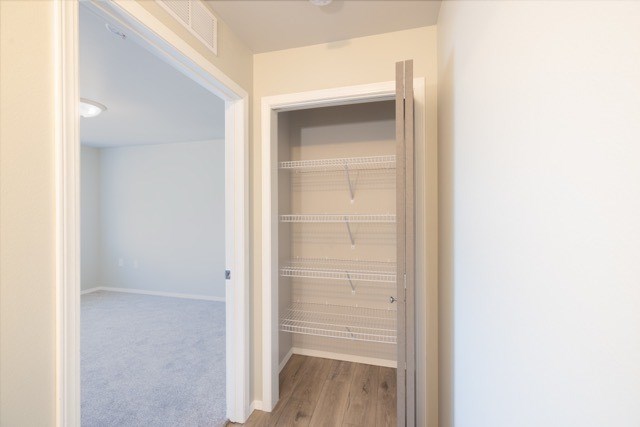 A white closet with a sliding door is open.