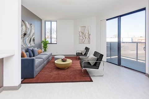 A living room with a grey couch, a yellow coffee table, and a painting on the wall.