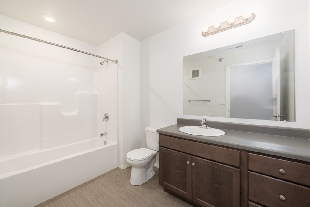 A white bathroom with a toilet, sink, and bathtub.