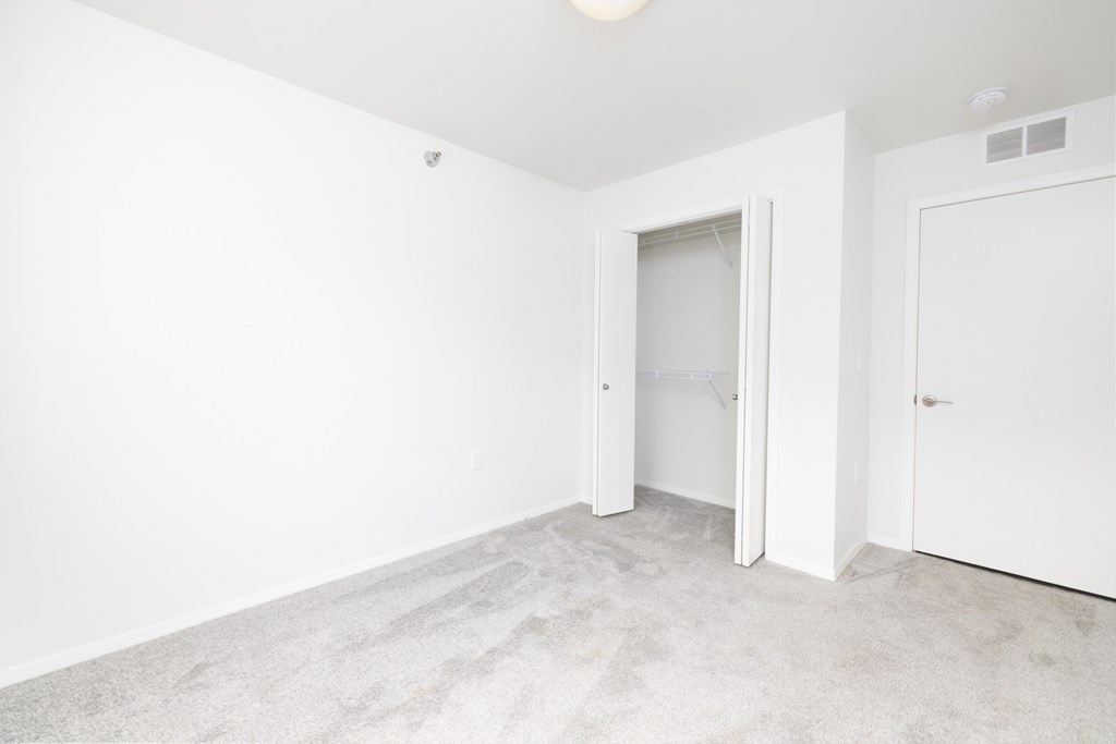 A white room with a carpeted floor and two doors.