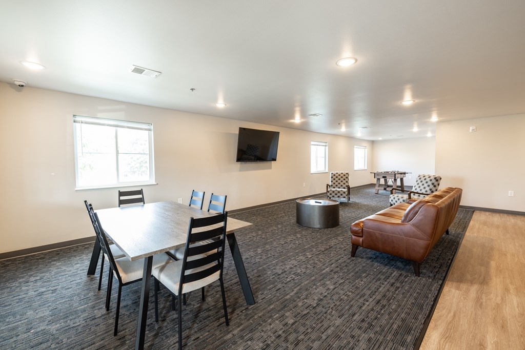 A conference room with a table, chairs, and a television.