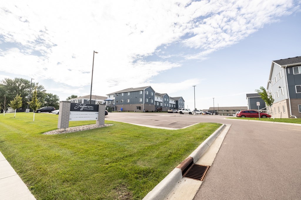 A sign in front of a building with a grassy area in front of it.