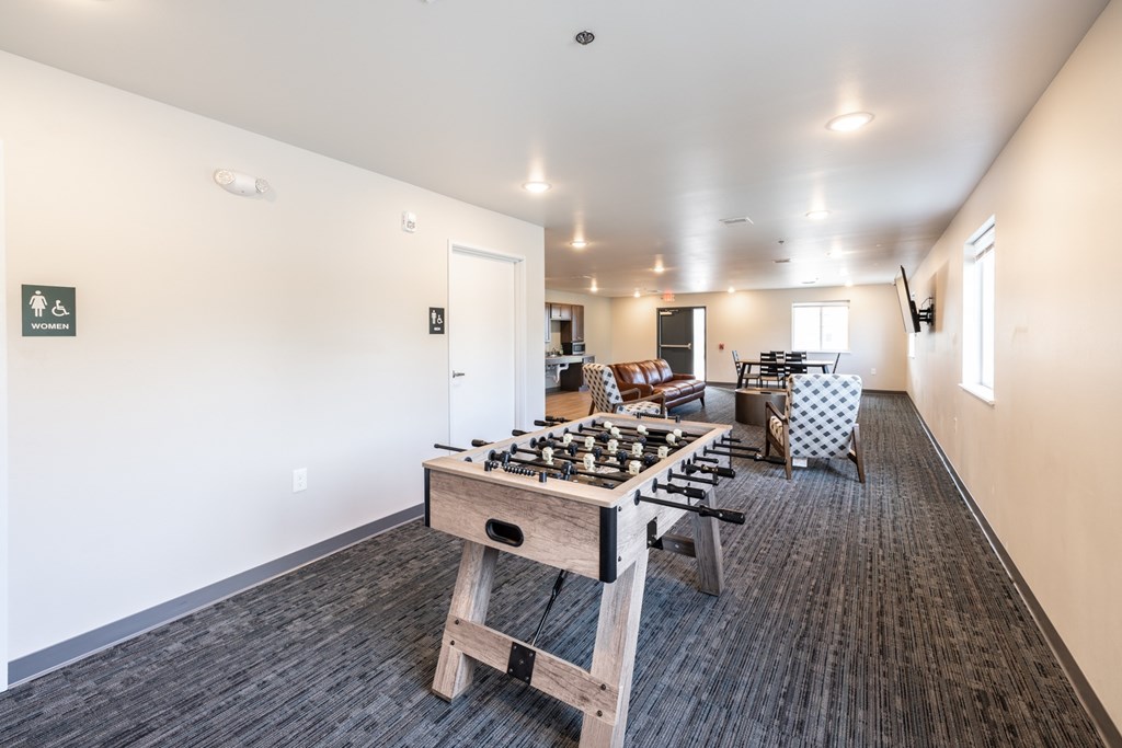 A room with a wooden table and chairs and a carpeted floor.