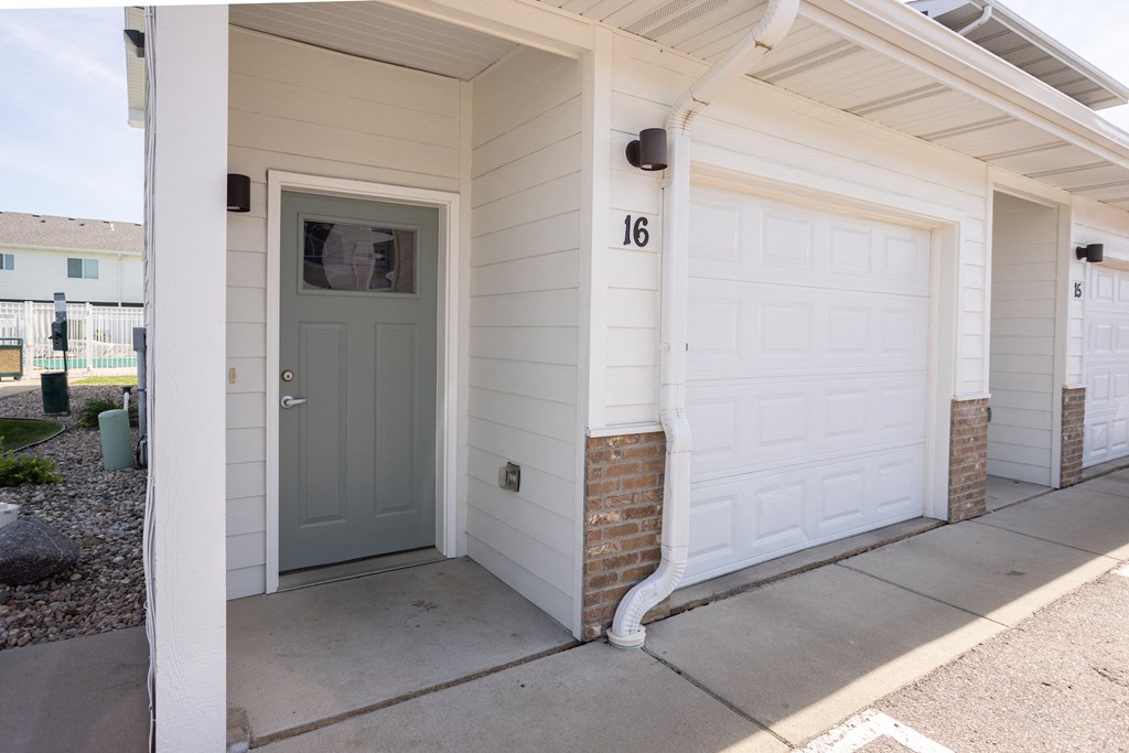 the front entrance of a white house with a blue door