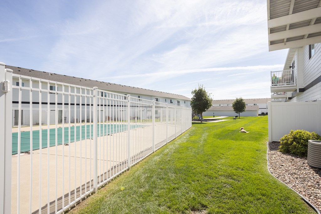 the side of a building with a pool and grass