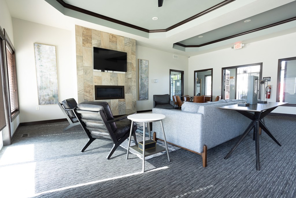 a living room with a couch table and chairs and a television