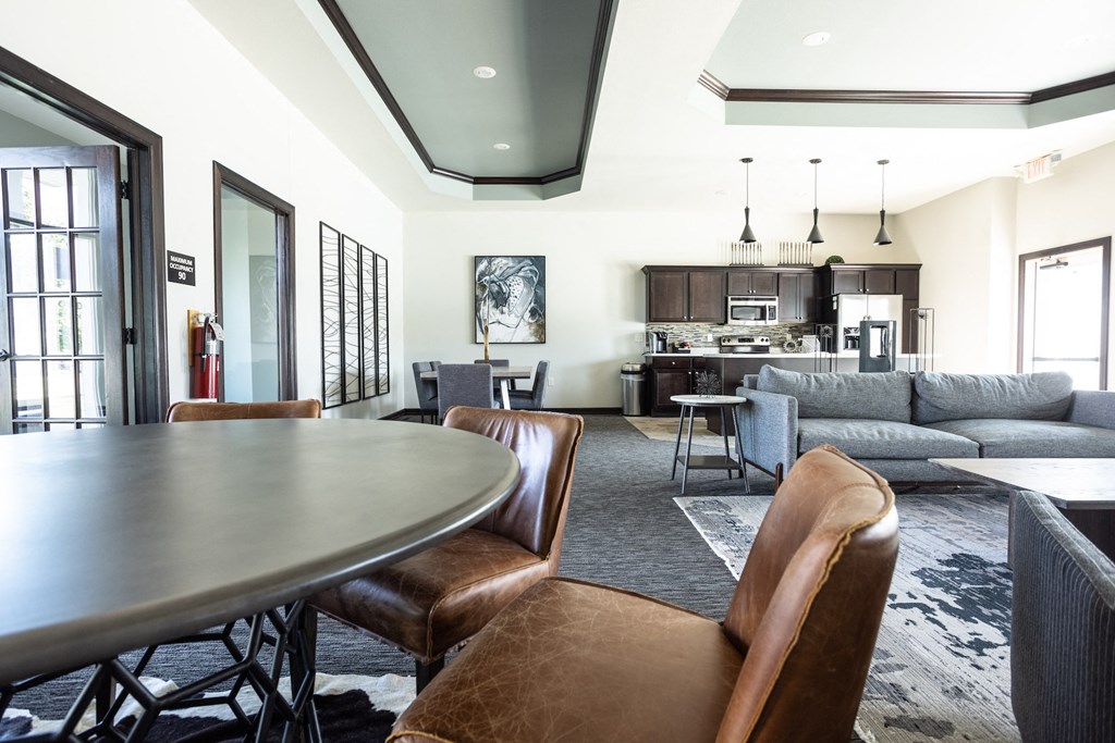 a living room with a table and chairs and a kitchen