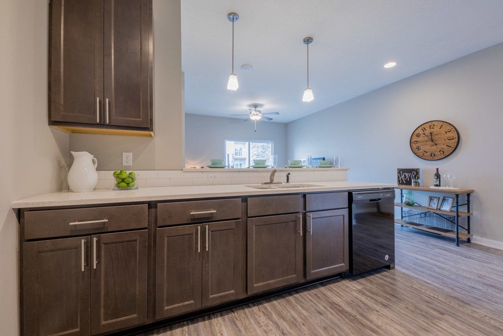a large kitchen with wooden cabinets and a clock on the wall