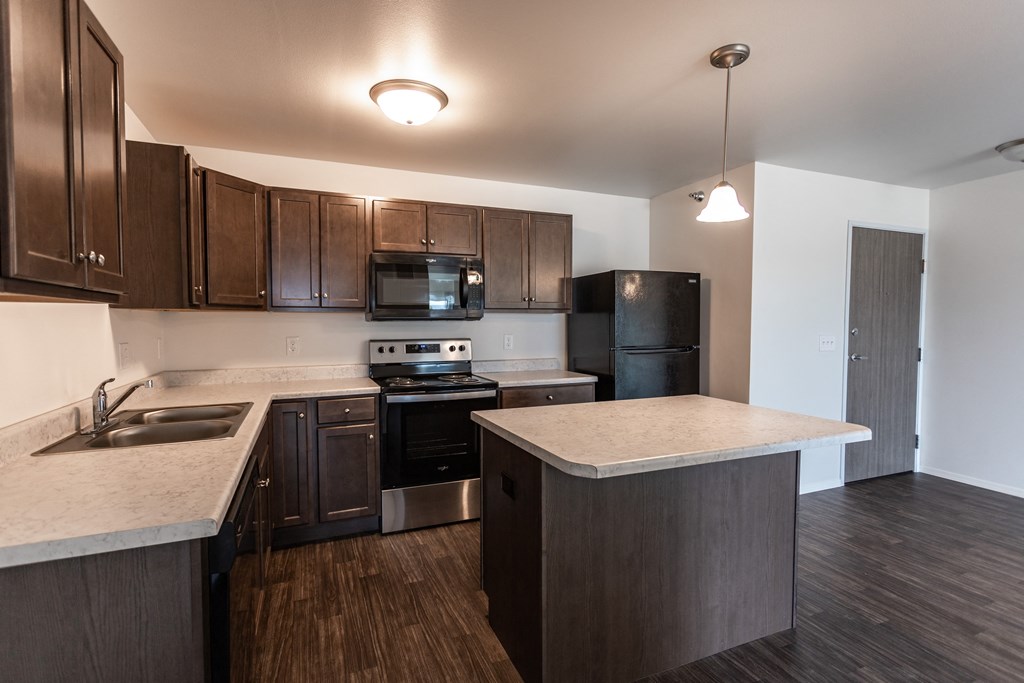 an empty kitchen with wooden cabinets and stainless steel appliances