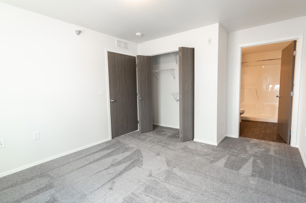 an empty room with a closet and a door to a bathroom