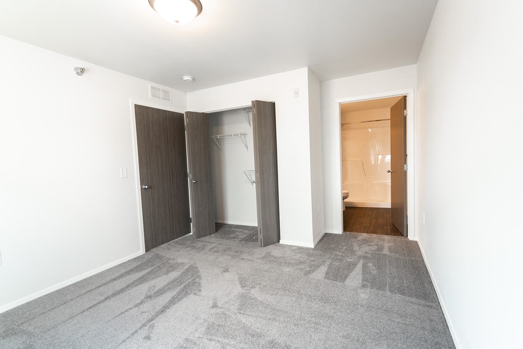 a renovated living room with white walls and a door to a bathroom