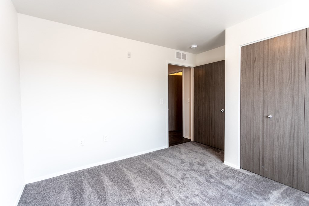 an empty room with white walls and a wooden door