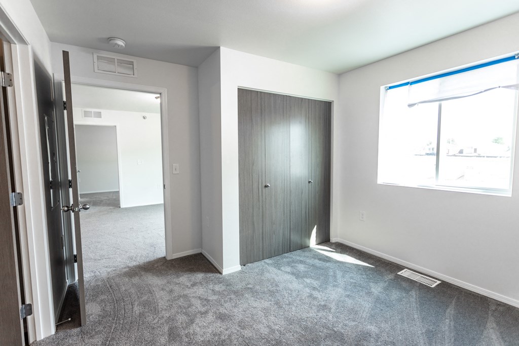 an empty room with a door and a window and a door to a closet