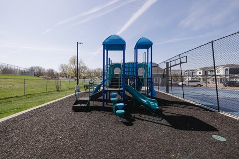 A playground with a blue slide and two blue towers.