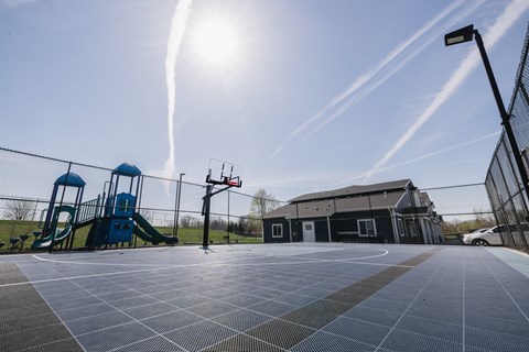 A basketball court with a blue slide in the background.