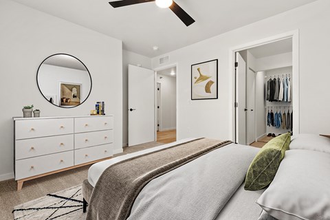 A bedroom with a bed, dresser, and mirror.